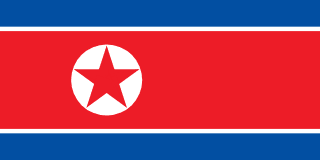 The flag of North Korea is composed of three horizontal bands — a large central white-edged red band, and a blue band above and beneath the red band. On the hoist side of the red band is a red five-pointed star within a white circle.