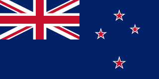 The flag of New Zealand has a dark blue field with the flag of the United Kingdom — the Union Jack — in the canton and a representation of the Southern Cross constellation, made up of four five-pointed white-edged red stars, on the fly side of the field.